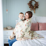 Load image into Gallery viewer, Mum holding and cuddling baby sitting on a bed wrapped in waffle blanket.
