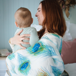Load image into Gallery viewer, Mum and bub wrapped in waffle blanket with peacock design.
