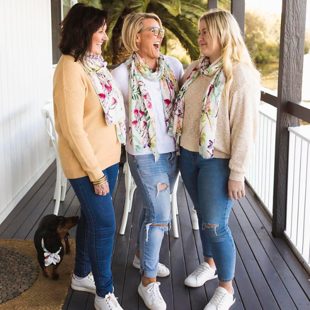 3 pretty ladies standing on balcony laughing and wearing the Oatley Bay scarf