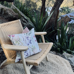 Load image into Gallery viewer, Cushion on garden chair with native flora design.
