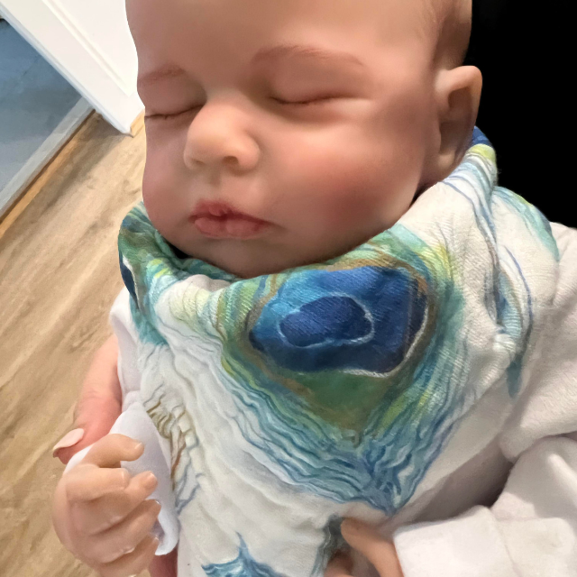 Baby wearing peacock feather print bib