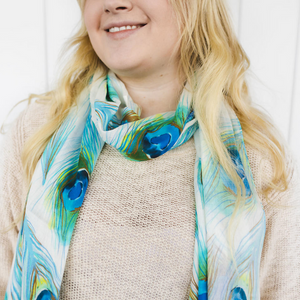 Smiling lady with blond hair wearing peacock print scarf around neck
